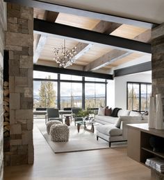 a living room filled with lots of furniture and a fire place in front of a large window