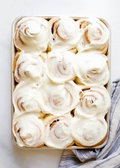 a pan filled with cinnamon rolls covered in icing