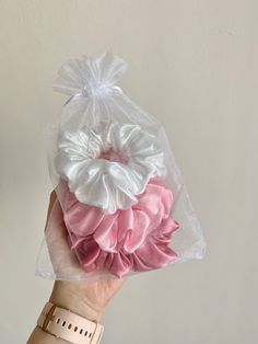 a hand holding a bag with pink and white ruffles