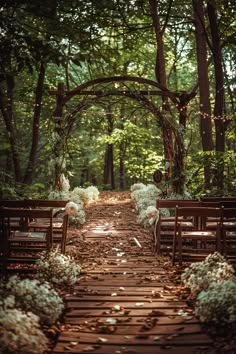 an outdoor ceremony with wooden chairs and flowers on the aisle, surrounded by trees in the background