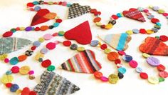 a table topped with lots of different colored pieces of cloth covered in buttons and beads