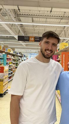 two men standing next to each other in a store aisle smiling at the camera,