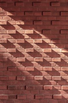 a red brick wall with shadows cast on it