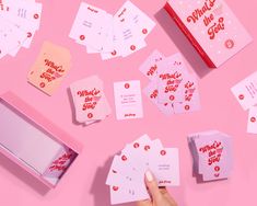 a person is holding up some pink cards