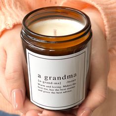 a woman holding a candle in her hands with the words grandma written on it's label