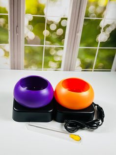 two different colored bowls sitting on top of a white table next to a pair of scissors