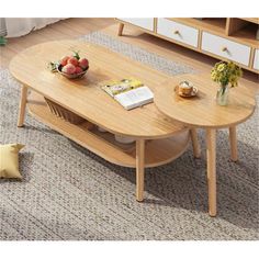 a wooden table with two oval shaped tables on top and a bowl of fruit in the middle