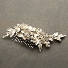 a hair comb with pearls and leaves on it