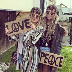 two women holding signs that say love and peace