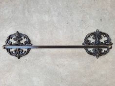 an ornately designed metal towel rack on the wall