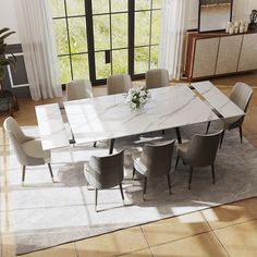 a dining room table with chairs and a rug in front of the window is shown