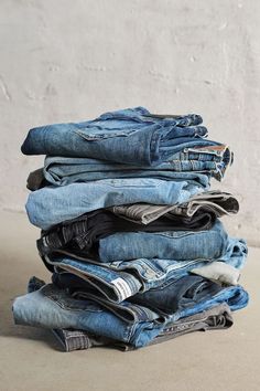 a stack of blue jeans sitting on top of each other