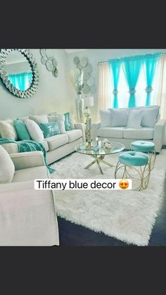 a living room filled with white furniture and blue curtains