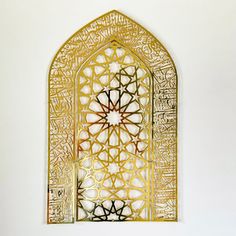 an intricately designed window in the middle of a wall with arabic writing on it