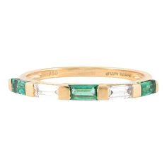 an emerald and diamond band ring with three baguets in yellow gold plated