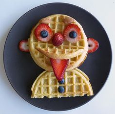 a waffle with strawberries and blueberries on it is decorated to look like a cartoon character