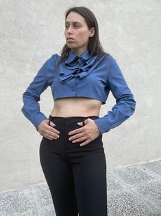 "1990s Romeo Gigli for Callaghan blue crop shirt with amazing work of jabot collar formed by the particular button closure, long sleeve 100% cotton Produced by Zamasport Marked size 42 (IT) Best fit: Small Made in Italy Condition: Excellent Measurements (taken flat): Shoulders: 41 cm / 16,1\" Armpit to armpit: 52 cm / 20,4\" Length: 35 cm / 13,7\" -- -- CONDITION GLOSSARY -- -- DEADSTOCK: the item is new, never be worned and it still has the label tag. EXCELLENT: the item is like new, it has no Fitted Cropped Shirt For Office, Fitted Long Sleeve Cropped Shirt For Work, Fitted Cropped Shirt With Buttons For Fall, Fitted Blue Cropped Shirt, Fitted Blue Cotton Cropped Shirt, Blue Fitted Cotton Cropped Shirt, Washed Blue Long Sleeve Shirt With Button Cuffs, Blue Fitted Top With Ruffled Collar, Vintage Washed Blue Tops With Button Closure