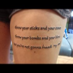 a woman with a tattoo on her thigh that says, throw your sticks and your stones