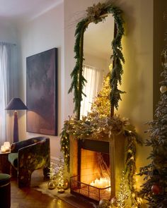 a living room decorated for christmas with a fire place and mantle covered in garlands