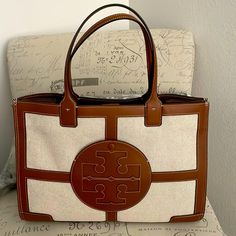 Never Used Tory Burch Leather And Material Tote. Immaculate Condition Tory Burch Handbag, Beige Monogram Canvas Shoulder Bag For Daily Use, Beige Monogram Canvas Top Handle Shoulder Bag, Luxury Beige Coated Canvas Shoulder Bag, Tan Monogram Canvas Shoulder Bag With Handles, Beige Monogram Canvas Bag With Double Handle, Tan Monogram Canvas Shoulder Bag For Errands, Beige Double Handle Monogram Canvas Bag, Beige Rectangular Monogram Canvas Shoulder Bag