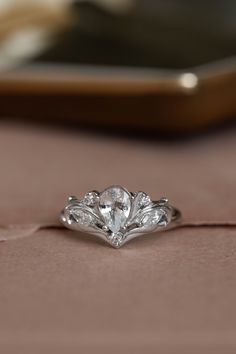 a diamond ring sitting on top of a pink cloth