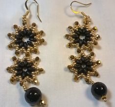 black and gold beaded earrings on white background