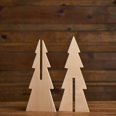 two wooden christmas trees on a table