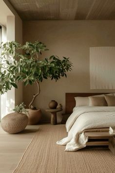 a bed sitting next to a plant in a bedroom on top of a wooden floor