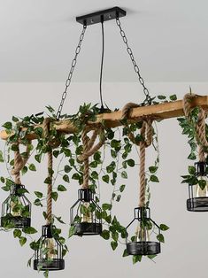 an arrangement of hanging planters made out of wood and rope with plants growing in them