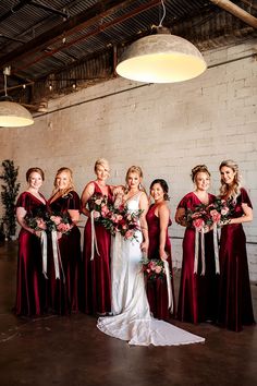 a group of women standing next to each other in front of a white brick wall