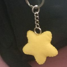 a yellow star shaped keychain hanging from a metal chain