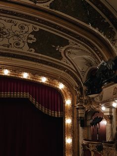 an ornately decorated auditorium with red curtains