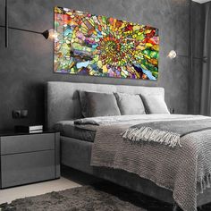 a bedroom with a large painting on the wall and a bed in front of it