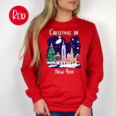 Christmas in New York Long-Sleeve T-Shirt, New York Christmas Vacation Gift, Christmas at Rockefeller Center, New York City Long Sleeved Tee. Orders are processed within 24 hours and shipped out within 2 to 5 business days.  What you receive: Gildan Mid-Weight Long-Sleeved Crewneck T-Shirt Color Choices: White Red Forest Green Sizes: Unisex adult sizing - these long-sleeved tees tend to run small - if you want a relaxed fit go one size larger. Shirt Detail: A bit more formal than a standard-issu Graphic Print Tops For New Year Holiday, Red Long Sleeve Tops For New Year, Long Sleeve Graphic Print T-shirt For Holiday, Long Sleeve Graphic T-shirt For Holidays, Red Crew Neck T-shirt For Holidays, New Year's Graphic Print Crew Neck Tops, New Year Graphic Print Crew Neck Tops, Festive Red Long Sleeve T-shirt, Christmas Vacation Gifts