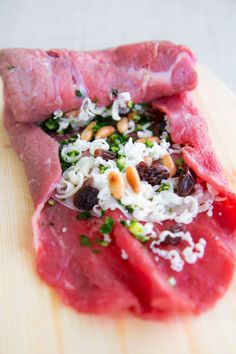 raw meat on a cutting board with nuts and herbs