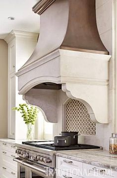 a stove top oven sitting inside of a kitchen next to white cabinets and counter tops