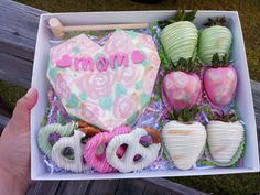 a box filled with lots of different types of doughnuts and strawberries next to each other