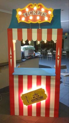 a carnival ticket booth with lights on it's sides and a sign that says tickets