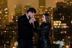 a man and woman standing next to each other in front of a cityscape