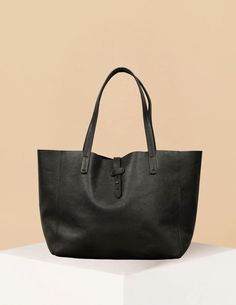 The Mika Bag is a sleek and versatile accessory designed for those who appreciate minimalist elegance. Crafted from premium leather and suede, this tote is perfect for both everyday use and special occasions. Its clean lines and structured silhouette provide a refined look, while its spacious interior allows you to carry all your essentials with ease. Featuring sturdy shoulder straps and a simple buckle closure, the Mika Bag is as practical as it is stylish. Available in luxurious jet black leat Minimalist Leather-lined Shoulder Bag For Work, Minimalist Shoulder Bag With Leather Lining For Work, Chic Everyday Bags With Leather Lining, Minimalist Workwear Shoulder Bag With Leather Lining, Minimalist Smooth Grain Shoulder Bag For Shopping, Minimalist Smooth Grain Shoulder Bag For Work, Minimalist Leather Shoulder Bag For Everyday, Minimalist Double Handle Shoulder Bag With Leather Lining, Minimalist Workwear Bag With Leather Handles