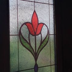 a stained glass window with a red flower on it