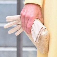 a close up of a person's hand holding gloves