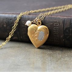 "This vintage locket is engraved with a floral design on the front; the reverse is plain. The gold filled heart opens revealing two compartments in which to place your favorite photos. The locket hangs from a new 14k gold filled cable chain accented with tiny freshwater pearl and finished with a lobster clasp. Locket 24x20mm Necklace length 18\" (45cm) ✦All of our vintage lockets ship with complimentary insurance✦ ✤Our entire selection of lockets can be found here✤ http://www.etsy.com/shop/Lexia Brass Heart Pendant Wedding Jewelry, Brass Heart Pendant Jewelry For Wedding, Heart-shaped Brass Jewelry For Wedding, Heart-shaped Brass Wedding Jewelry, Gold Jewelry With Engraving Option For Wedding, Traditional Heart Jewelry For Wedding, Traditional Heart-shaped Jewelry For Weddings, Traditional Gold Jewelry With Engraving Option, Traditional Heart-shaped Wedding Jewelry