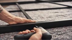 a man is using a tool to cut up a piece of wood on the floor