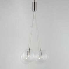 three clear glass globes hanging from a chrome ceiling light fixture in a white room