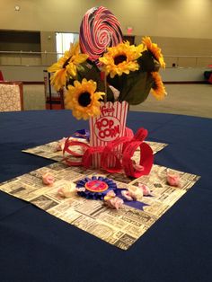 a bouquet of sunflowers in a paper bag on top of a blue table cloth