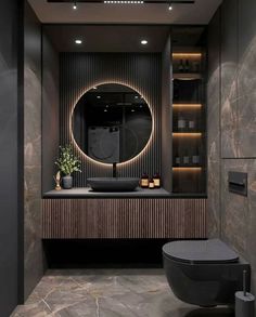 a bathroom with a round mirror above the sink and a black toilet in front of it