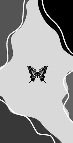 a black and white photo with a butterfly on it's back side, against a gray background