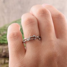 a person's hand with a silver ring on it