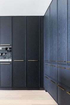 a kitchen with black cabinets and gold trimmings on the doors, along with an oven